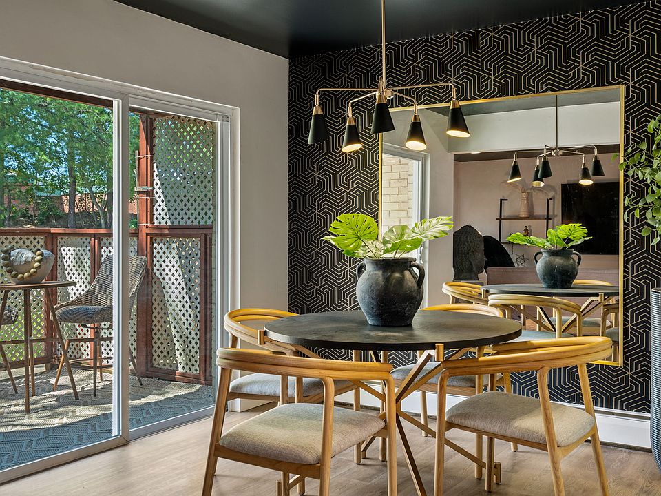 Beautiful dinning room with stunning wallpaper backdrop anchored by a large mirror which gives the room depth. The black ceiling and mid century style chandalier add a touch of elegance. Patio sliders lead out to your private patio area and outdoor grill.