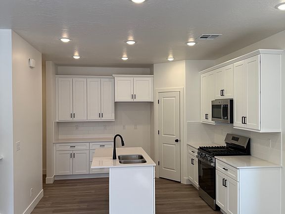 Spacious kitchen with stainless appliances and large pantry.