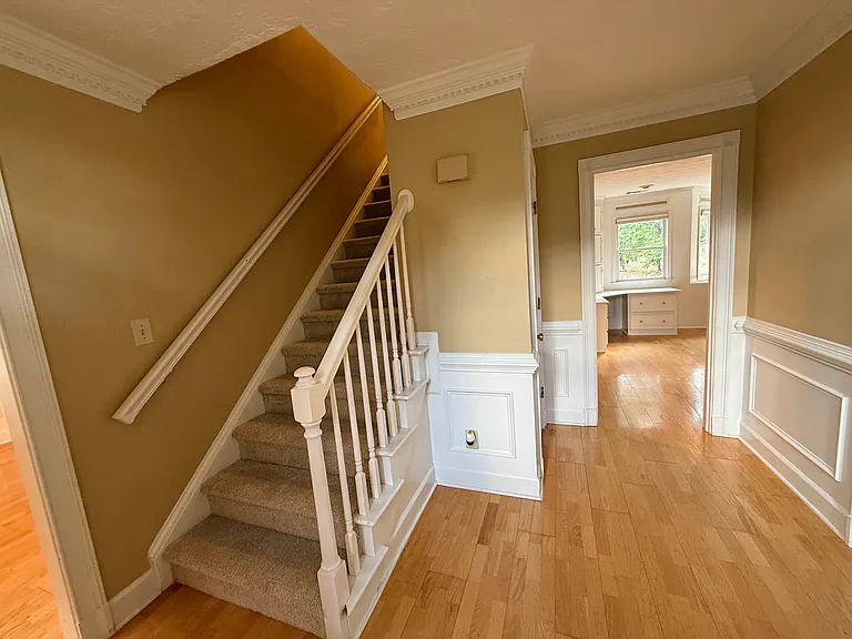 A foyer that opens into the dining room, formal living room, family room, and the staircase to the second floor