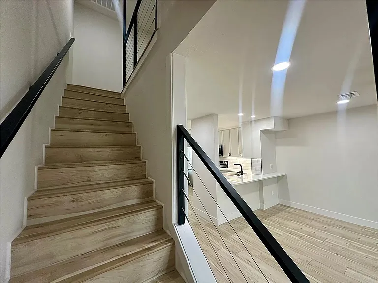 Stairway to upstairs and view of the downstairs living space onto the kitchen. Living area furnished, see other photos.