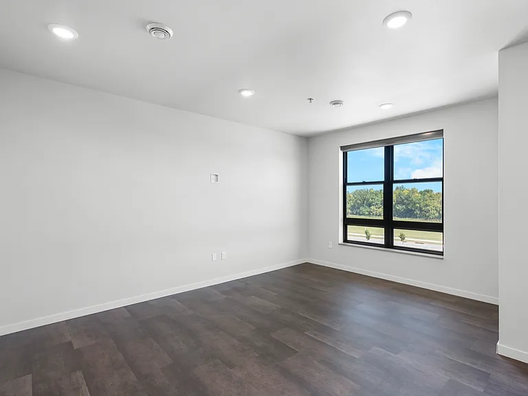 Bright and spacious room with large window, offering a serene view and modern flooring. Bright and spacious room with large window, offering a serene view and modern flooring.