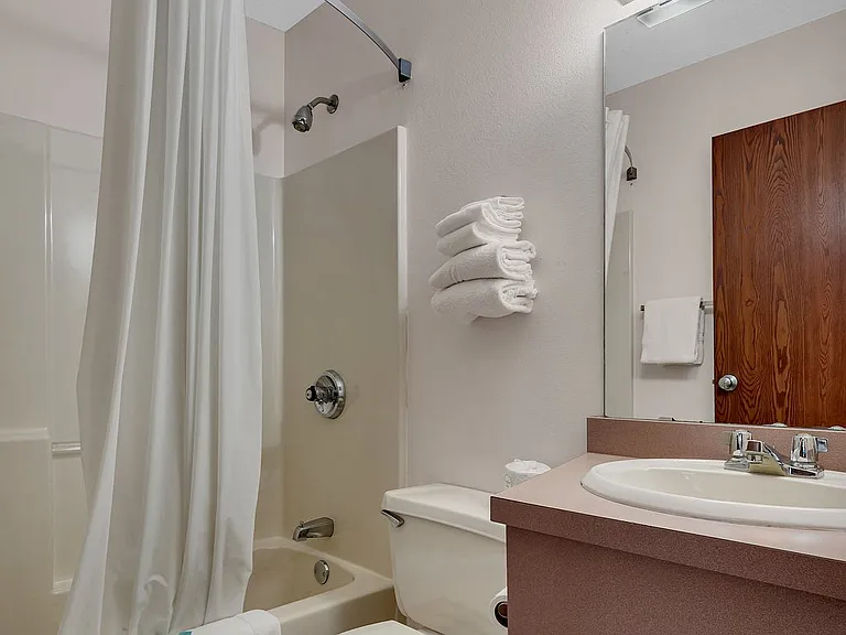 Full bathroom with tub/shower combo, large vanity, and ample storage space.