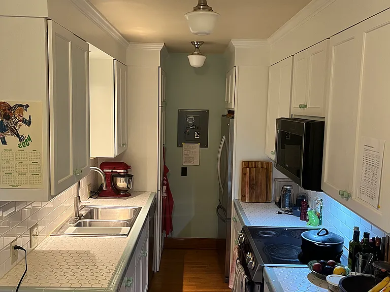 Updated galley kitchen with stainless steel appliances and laundry.