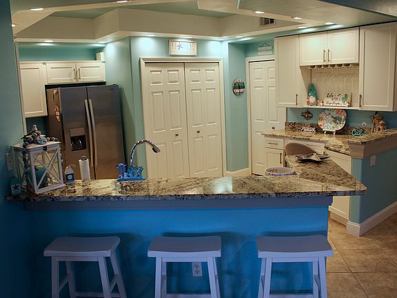 Dine in the kitchen with three bar stools.