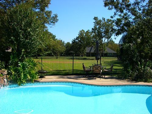 View of pool and golf course. Pool has a safety net.