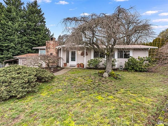 The front yard boasts mature landscaping and ornamental trees.