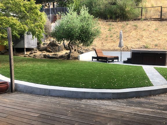 backyard with turf and hot tub
