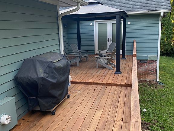 Back deck with portico and Adirondack chairs, attached to breezeway.