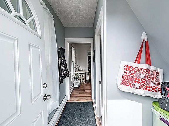 Primary entrance opens to short hallway, with bathroom on the right and kitchen directly ahead.