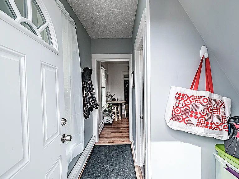 Primary entrance opens to short hallway, with bathroom on the right and kitchen directly ahead.