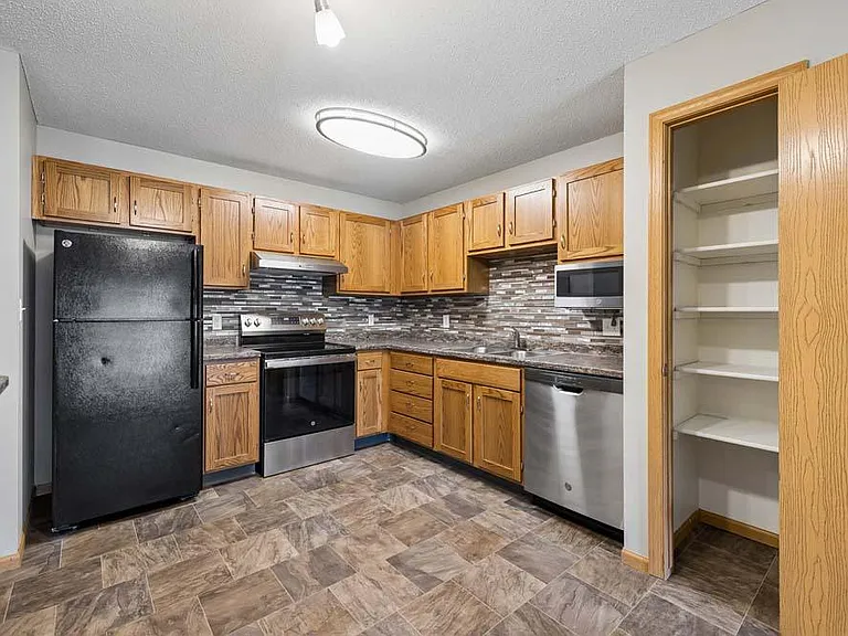 Thoughtfully designed with abundant cabinetry, a stylish tile backsplash, and a convenient pantry, this inviting kitchen makes everyday cooking feel effortlessly organized.