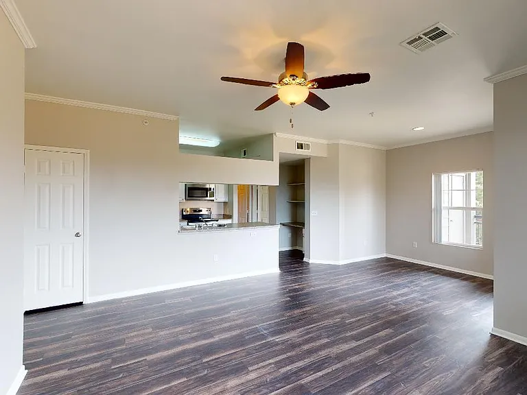 Apartment kitchen, dining and living room with wood-style flooring in select homes.