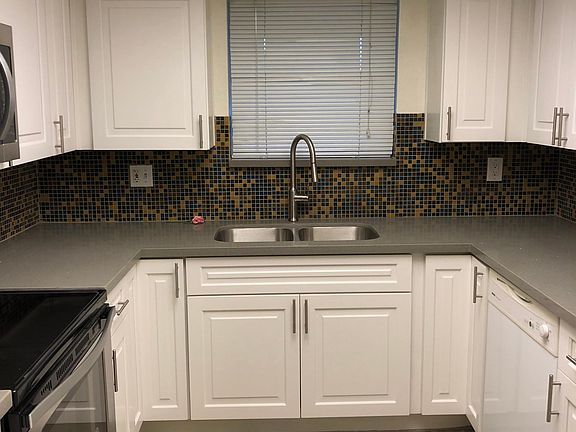Newly remodeled contemporary kitchen highlighted by elegant quartz counter tops and real wood cabinets with self-closing drawers and two lazy-Susans.