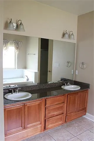 En-suite bath- Double vanities with granite, wooden cabinets, ceramic flooring, jetted tub, separate shower, and huge walk in closet.