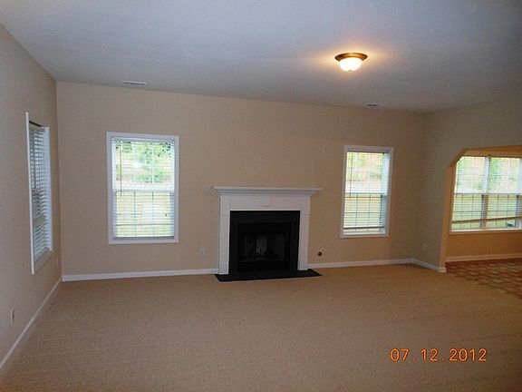 Big great room with fireplace opens to porch and to kitchen