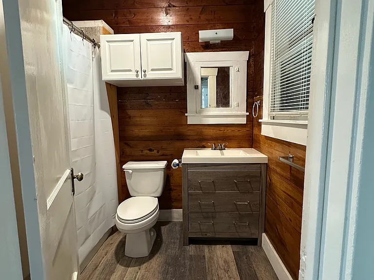 Bathroom with vanity and storage cabinet.
