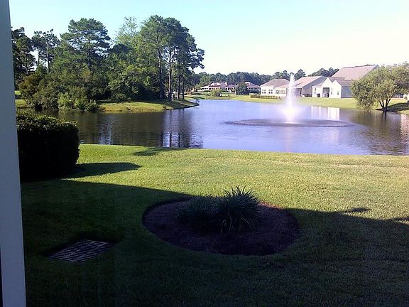 view across lake with golf course clubhouse in background