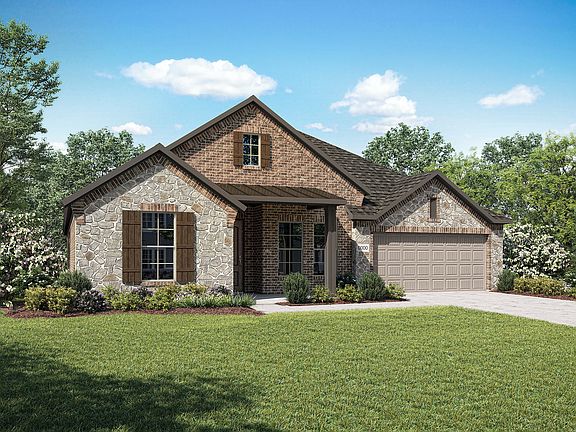 A two-story brick and stone house with a gabled roof sits on a well-manicured lawn, surrounded by lu