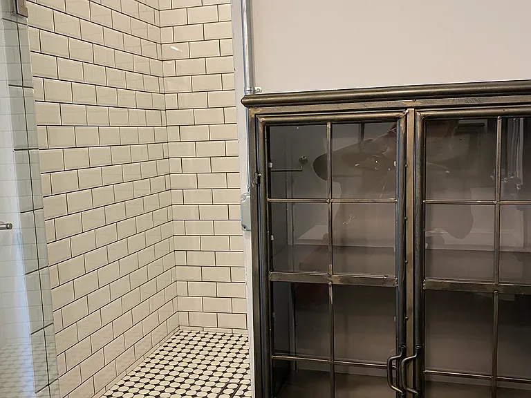 Custom tile shower and cabinet in bathroom