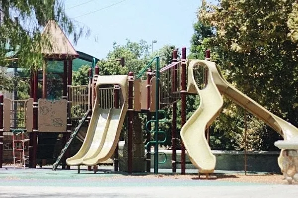 Neighborhood Playground with Swings, Slides, and Shaded Play Areas