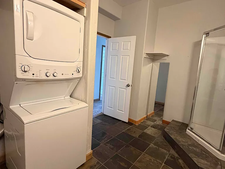 Bathroom includes shower, toilet, sink/vanity, and washer/dryer stack