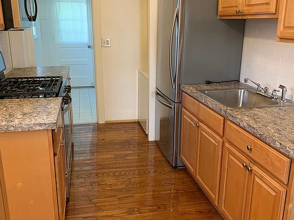 Kitchen with new cabinets, countertops, appliances, and refinished hardwood floor.