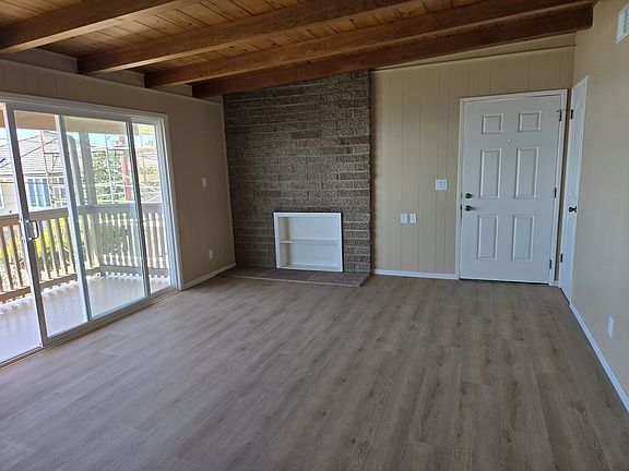 Open beam living room with ocean view and balcony.