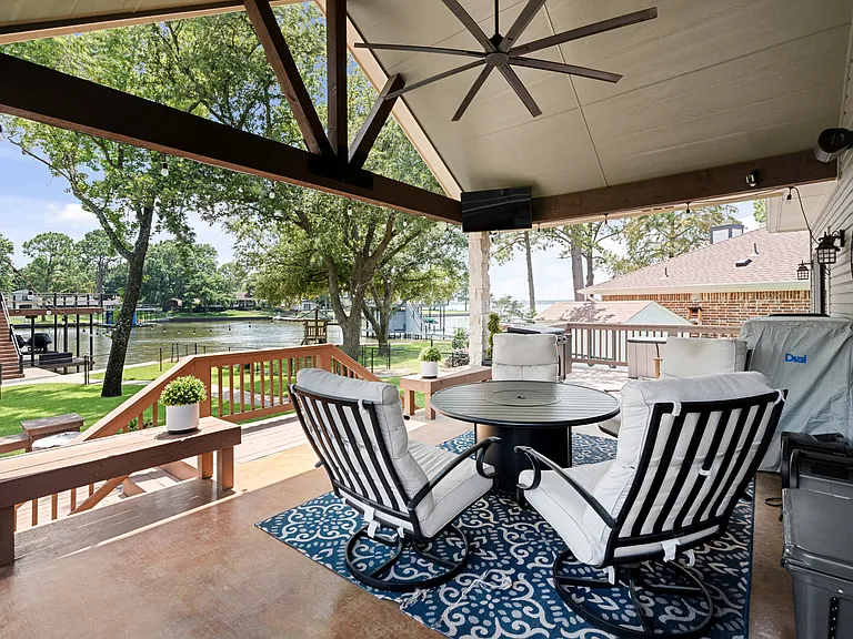 Covered porch with ceiling fan with round table and seating for 4.