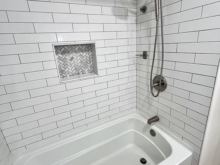Master bathroom with built-in medicine cabinet, tub, shower/sprayer combo, and waterproof Pergo floors.