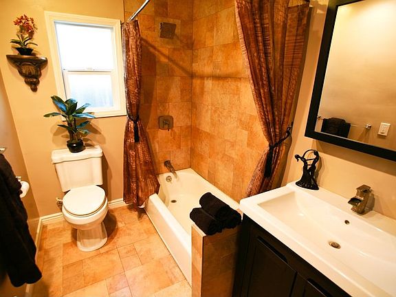 The full bath features tile and a gorgeous dark wood cabinet