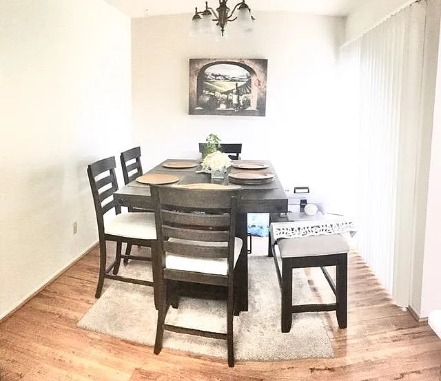 Older picture of actual unit dining room showing it has no window, but does have the a wall of patio door to the front porch for plenty of natural light.