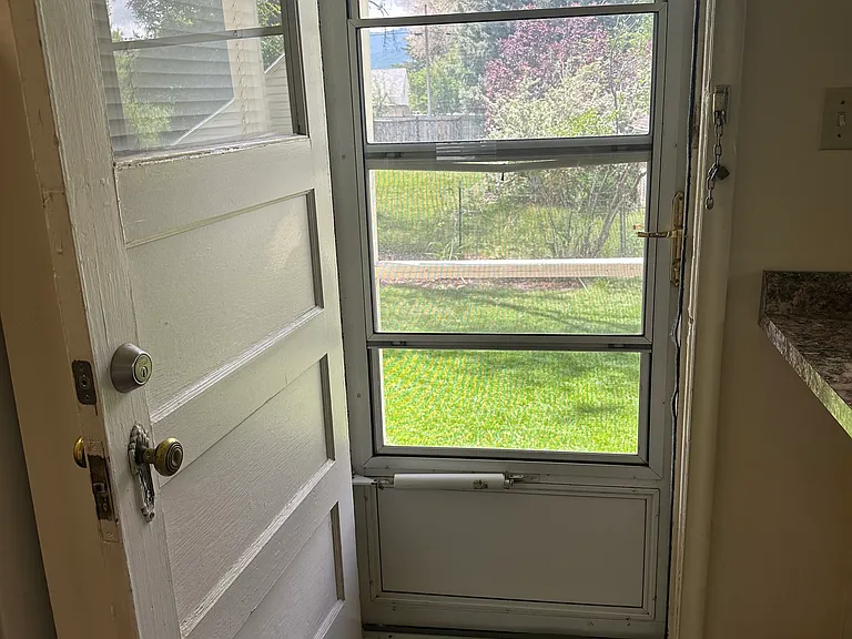 Private backyard entrance with screen door