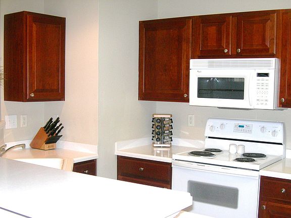 Rich Cherry stained cabinets with white appliances