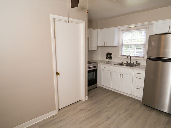 Full view of the brand new kitchen including a ceiling fan.