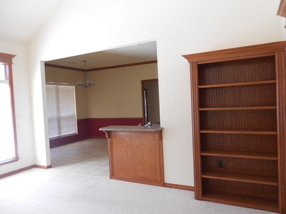 Living, view 2, builtins, breakfast bar adj to kitchen