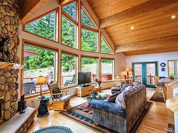 Stunning great room with vaulted tongue & goove wood ceilings and wood floors. Gorgeous river rock fireplace with stone hearth & wood accent mantle. Propane fireplace with fan to keep things cozy in the winter!