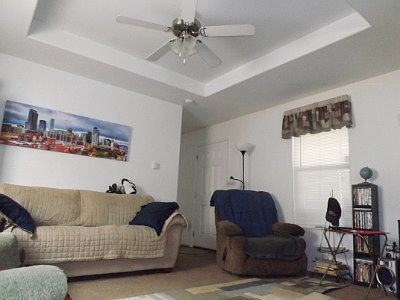 Beautiful Living Room with tray ceiling and fan