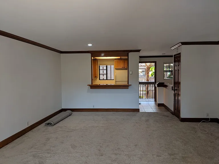 Condo entryway into living space with peek through to kitchen