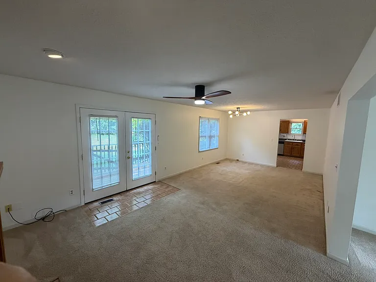 Great room with new ceiling fan and modern light fixture in dining area