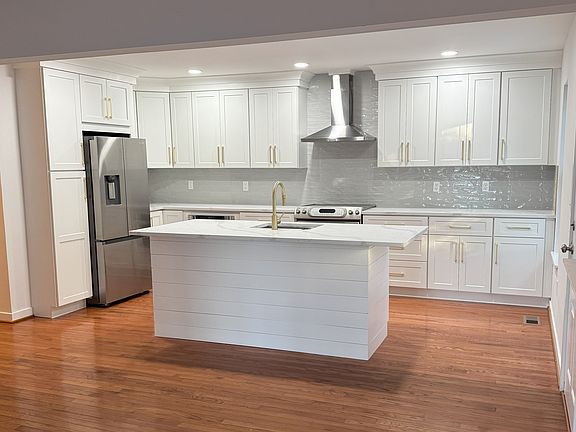 Kitchen fully renovated with custom cabinets, new quartz countertop, new sink, new disposal, new exhaust hood, new tile backsplash.