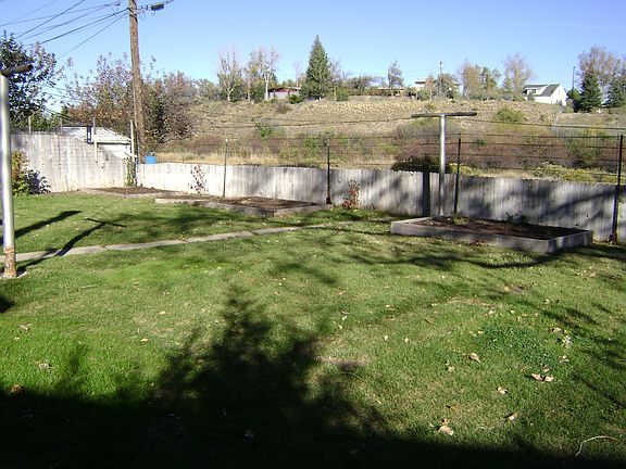 Backyard with raised garden beds, backs up to garden creek