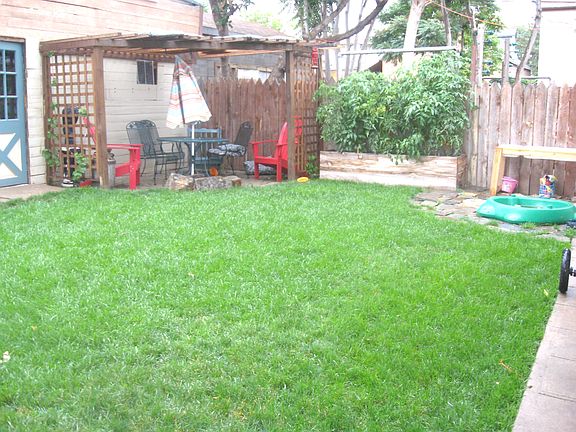 backyard with pergola, grape vines, firepit, garden bed (4 total), lush grass!