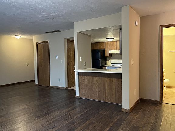Looking at the front door entrance, coat closet and kitchen.