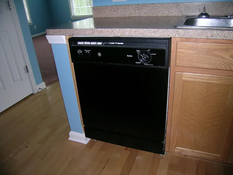 1975 Nocturne Drive
View of kitchen island with dishwasher.
Note: The paint is now beige and not blue.
