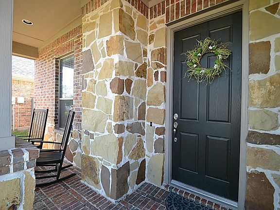 Front doorway and porch accented in stone inviting you inside.