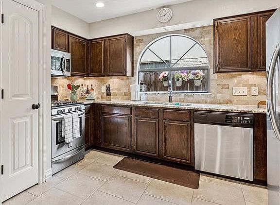 Beautiful kitchen, dark cabinets, SS appliances, granite countertops and stylish back-splash