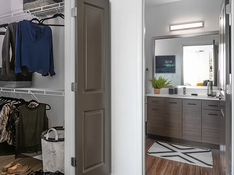 Apartment bathroom with large soaking tub and wood-style flooring and spacious closet.
