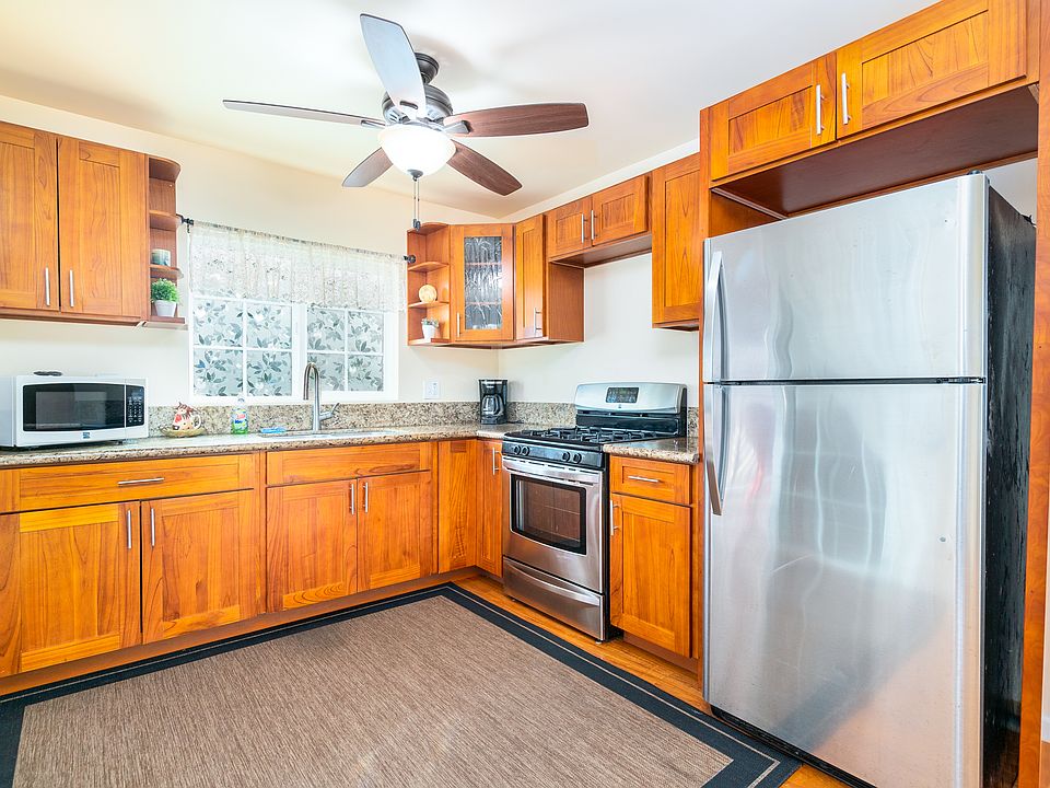 Bright, modern kitchen with solid wood cabinetry, granite counters, gas range, and stainless steel appliances.