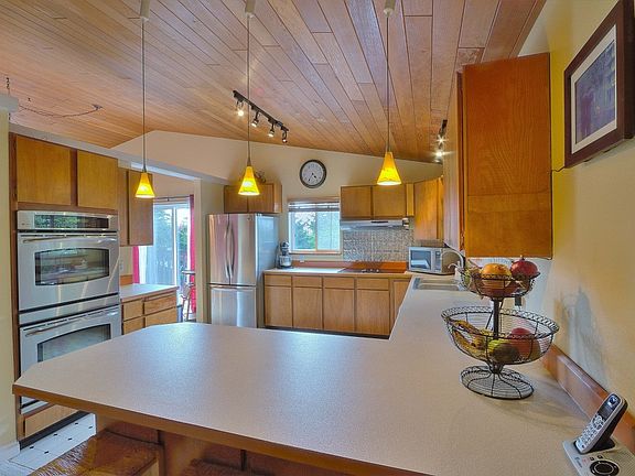 Peninsula kitchen with top of the line stainless steel appliances including double GE Profile ovens,