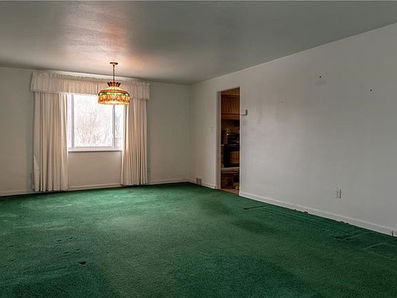 View of dining area from the living room.  There are hardwood floors under the carpeting.